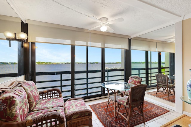 sunroom featuring a water view and ceiling fan