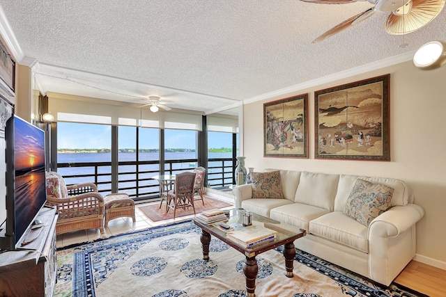 living room with crown molding, a water view, and a textured ceiling