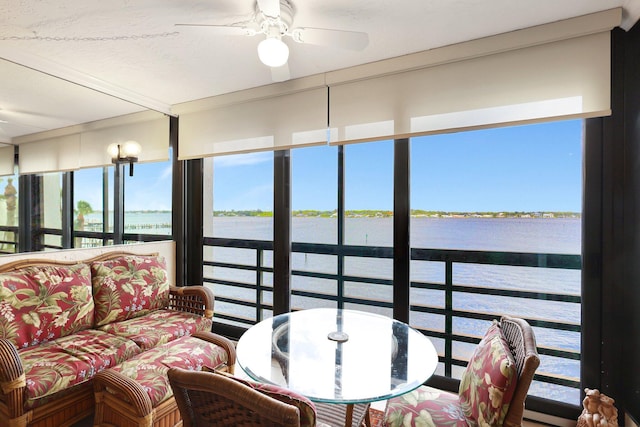 sunroom / solarium with a water view and ceiling fan