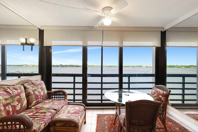 sunroom / solarium with ceiling fan and a water view