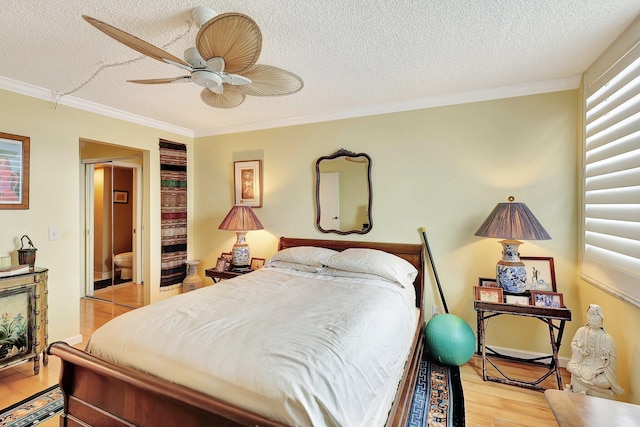 bedroom with ceiling fan, crown molding, light hardwood / wood-style floors, and a textured ceiling