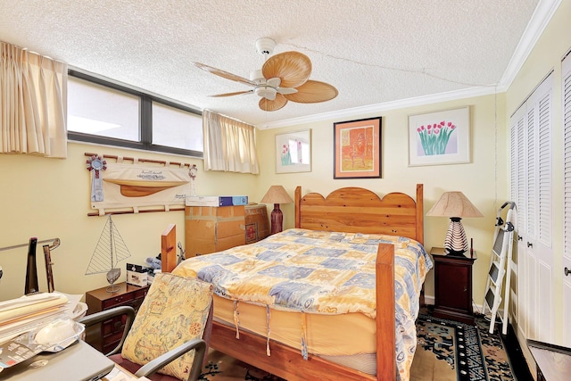 bedroom with a textured ceiling, a closet, ceiling fan, and ornamental molding