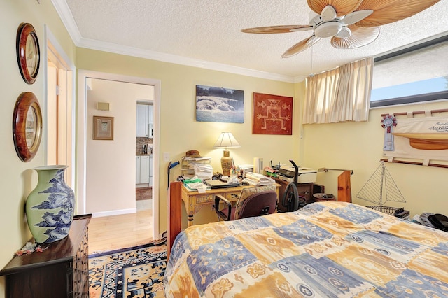 bedroom with hardwood / wood-style floors, ceiling fan, ornamental molding, and a textured ceiling