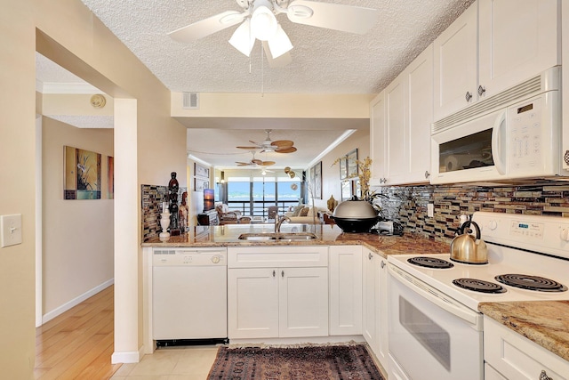 kitchen featuring backsplash, sink, white cabinets, and white appliances