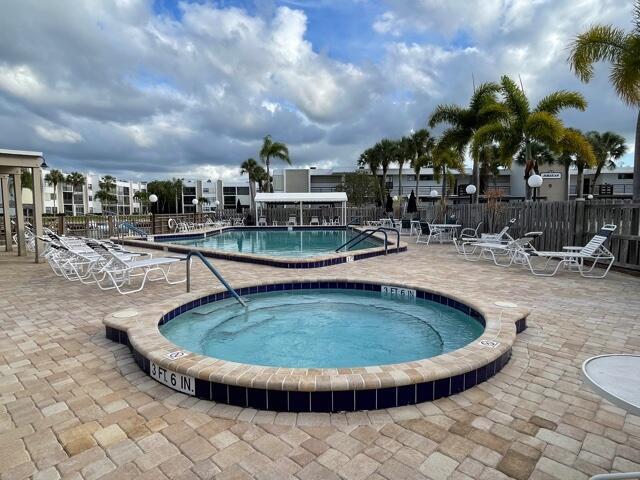 view of swimming pool featuring a community hot tub and a patio