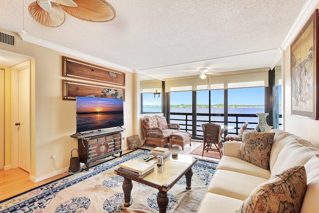 living room featuring a textured ceiling, ceiling fan, crown molding, and hardwood / wood-style flooring