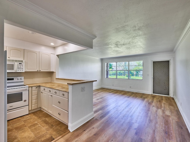 kitchen featuring kitchen peninsula, a textured ceiling, white appliances, crown molding, and white cabinetry