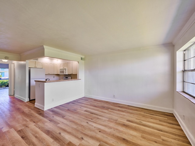 kitchen featuring kitchen peninsula, light wood-type flooring, fridge, white cabinets, and ornamental molding