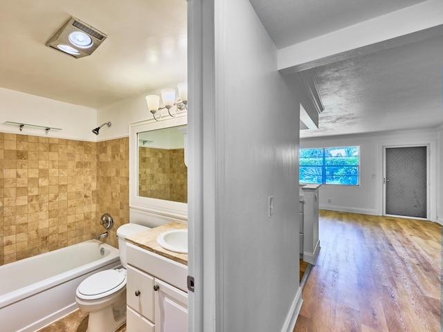 full bathroom featuring tiled shower / bath combo, hardwood / wood-style floors, a chandelier, toilet, and vanity