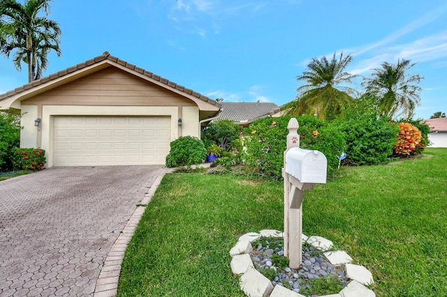 ranch-style home featuring a front lawn and a garage