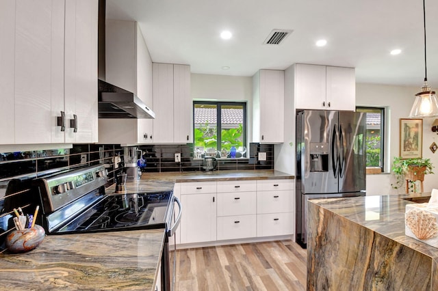 kitchen with stainless steel appliances, decorative light fixtures, stone counters, white cabinets, and light hardwood / wood-style flooring