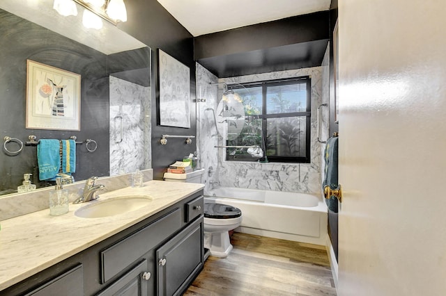 full bathroom featuring toilet, vanity, tiled shower / bath, and wood-type flooring