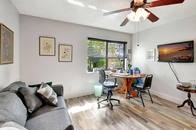 office space featuring light wood-type flooring, a textured ceiling, and ceiling fan