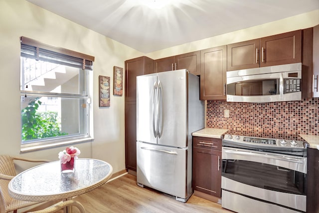 kitchen featuring light hardwood / wood-style floors, dark brown cabinetry, appliances with stainless steel finishes, and tasteful backsplash