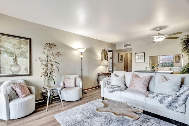 living room with ceiling fan and light hardwood / wood-style flooring