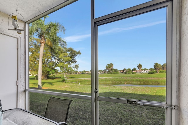 sunroom featuring a water view