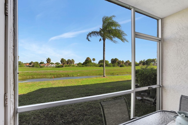 sunroom / solarium featuring a water view