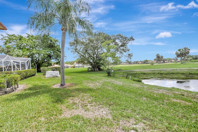 view of yard with a water view and a lanai