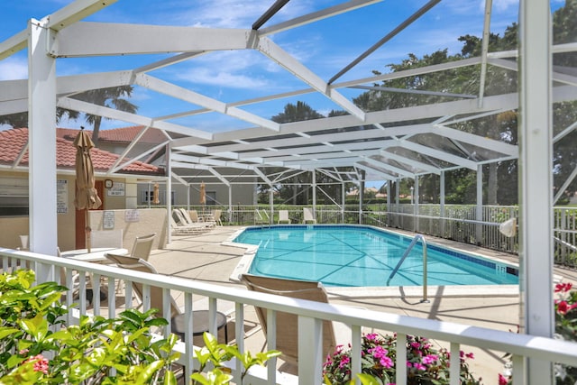 view of pool featuring glass enclosure and a patio area