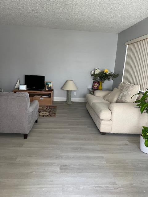 living room featuring a textured ceiling and light wood-type flooring