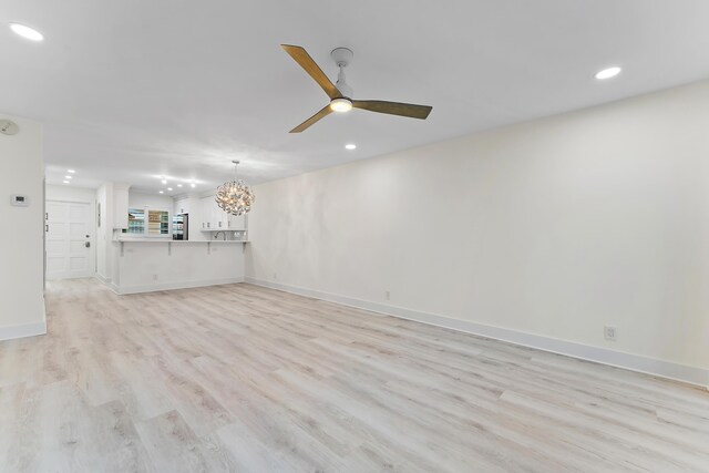 spare room with ceiling fan and light wood-type flooring