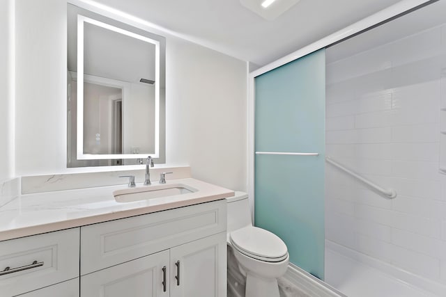 bathroom featuring vanity, an enclosed shower, and toilet