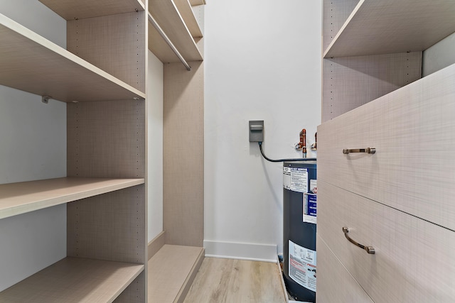 spacious closet featuring light hardwood / wood-style flooring and gas water heater