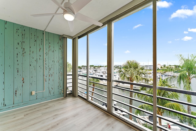 unfurnished sunroom with a wealth of natural light and ceiling fan