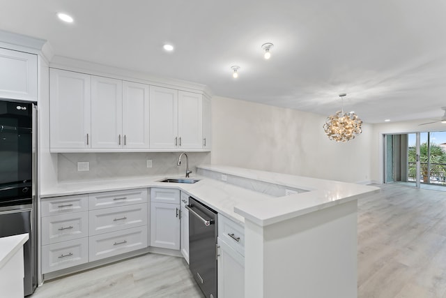 kitchen with white cabinets, sink, dishwasher, light hardwood / wood-style floors, and kitchen peninsula