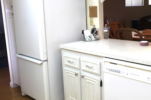 kitchen featuring white appliances and dark hardwood / wood-style floors