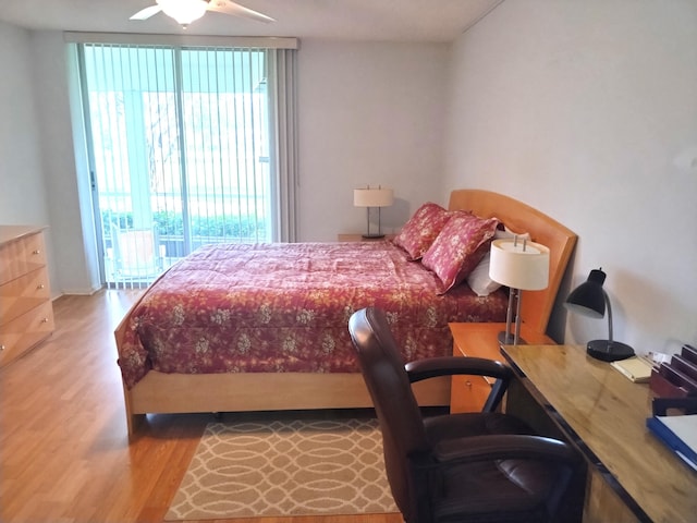 bedroom with hardwood / wood-style floors and a wall of windows