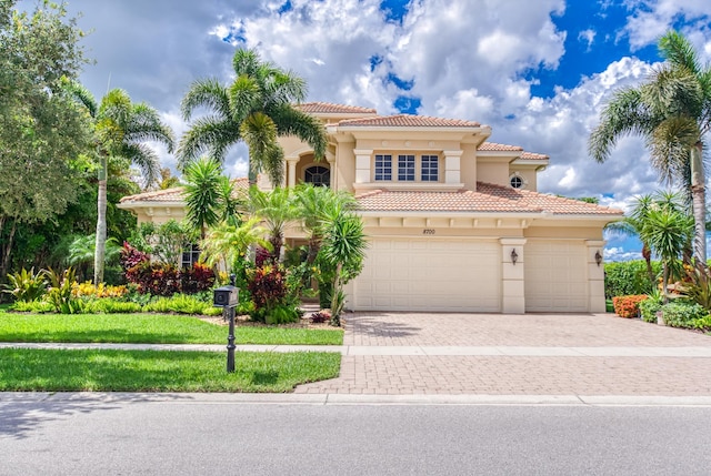 mediterranean / spanish house with a garage and a front lawn