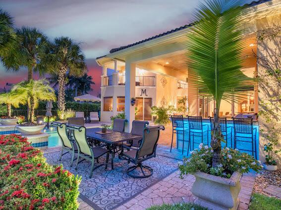 patio terrace at dusk with a fenced in pool and a balcony