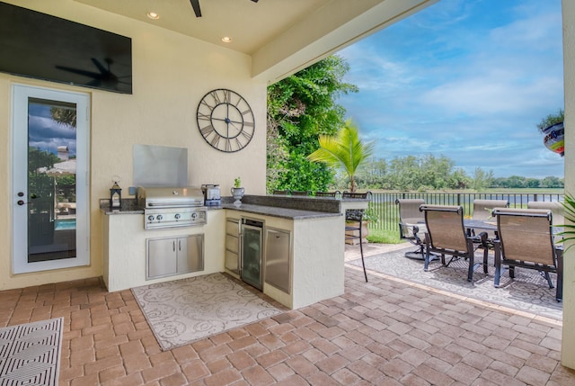 view of patio / terrace with a grill, a water view, area for grilling, and ceiling fan