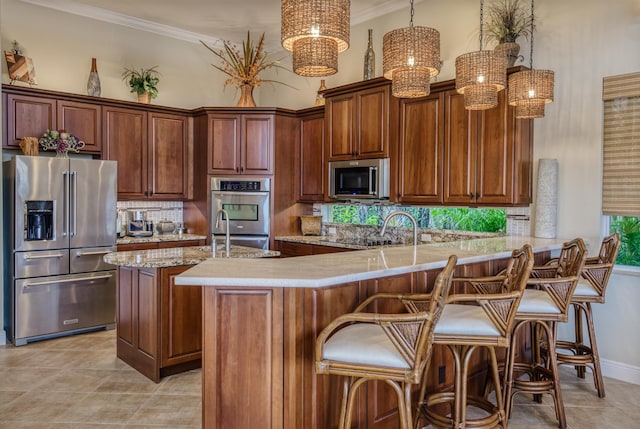 kitchen featuring appliances with stainless steel finishes, pendant lighting, a kitchen breakfast bar, light stone counters, and kitchen peninsula