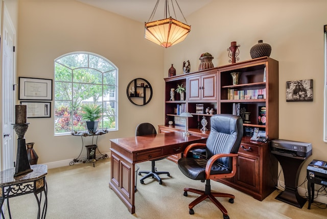 office with vaulted ceiling and light carpet