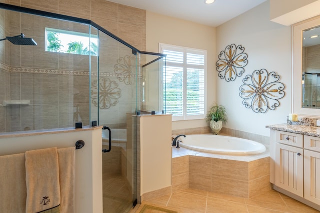 bathroom featuring tile patterned flooring, plus walk in shower, a healthy amount of sunlight, and vanity