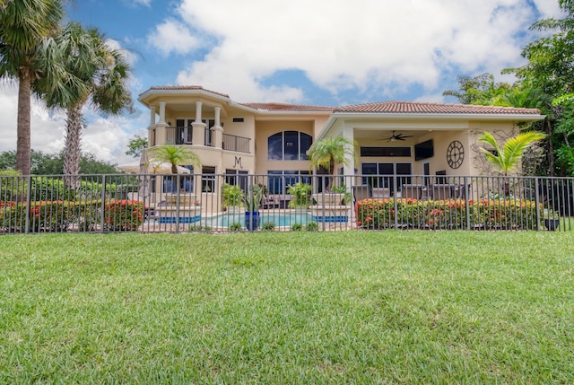 back of house with a fenced in pool, a yard, a balcony, and ceiling fan