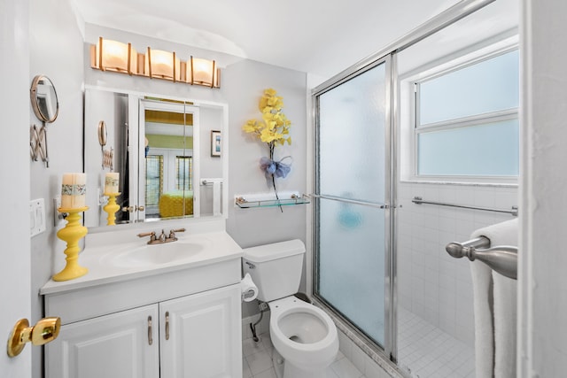 bathroom featuring tile floors, an enclosed shower, toilet, and vanity with extensive cabinet space