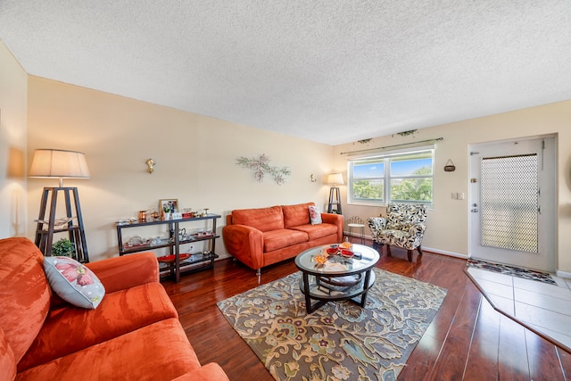 living room featuring dark wood-type flooring and a textured ceiling