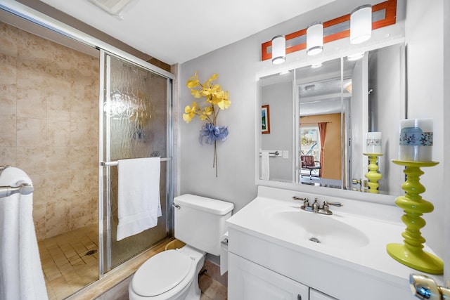 bathroom featuring a shower with shower door, toilet, and large vanity