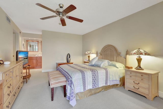 bedroom featuring connected bathroom, ceiling fan, and light carpet