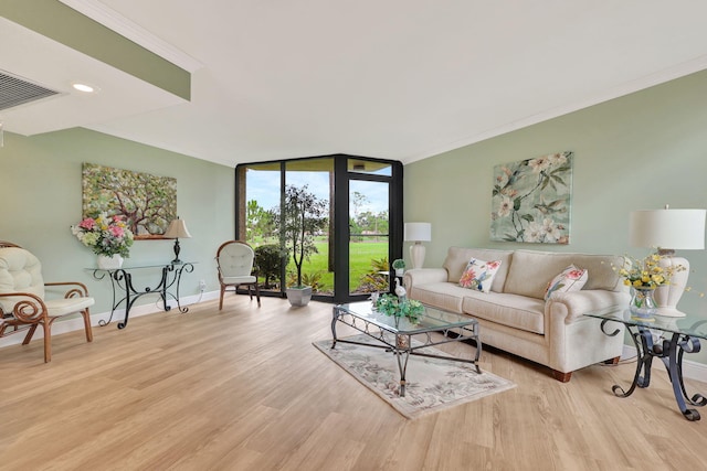 living room featuring expansive windows, ornamental molding, and light wood-type flooring