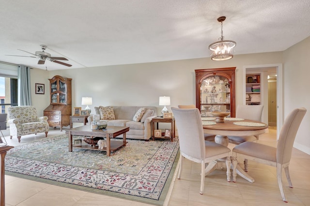 tiled living room with a textured ceiling and ceiling fan with notable chandelier