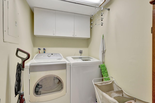 laundry area featuring cabinets, independent washer and dryer, and electric panel