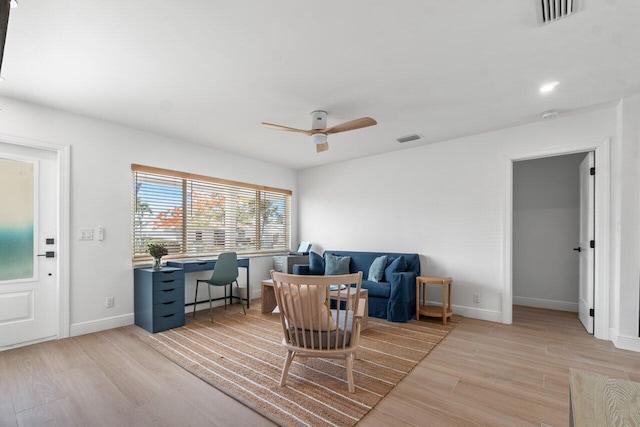 living room with ceiling fan and light hardwood / wood-style flooring