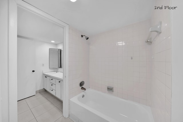 bathroom with tile patterned flooring, vanity, and tiled shower / bath