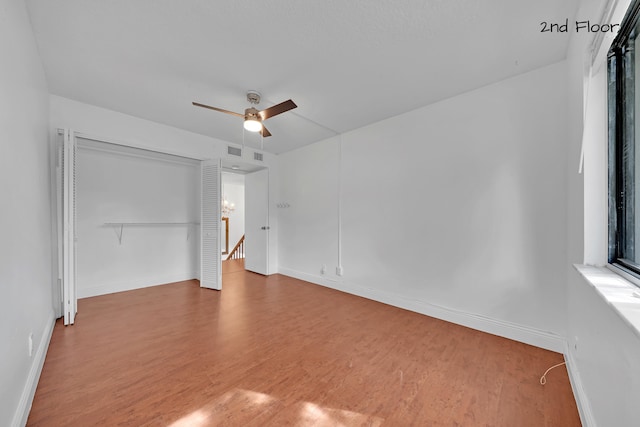 unfurnished bedroom with ceiling fan, a closet, and wood-type flooring