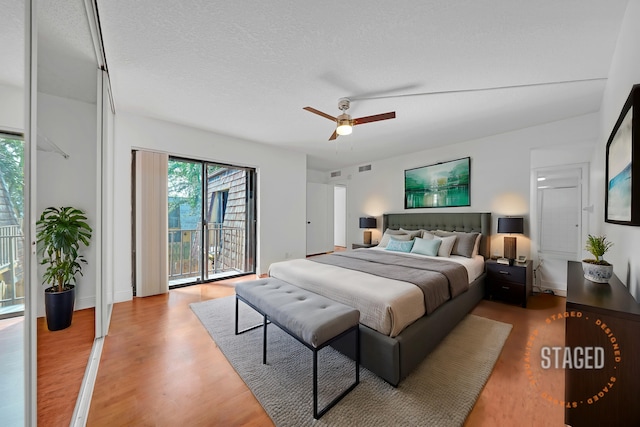 bedroom featuring a textured ceiling, access to outside, hardwood / wood-style flooring, and ceiling fan