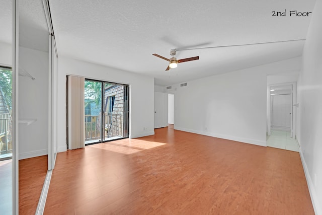 spare room featuring light hardwood / wood-style flooring, a textured ceiling, and ceiling fan